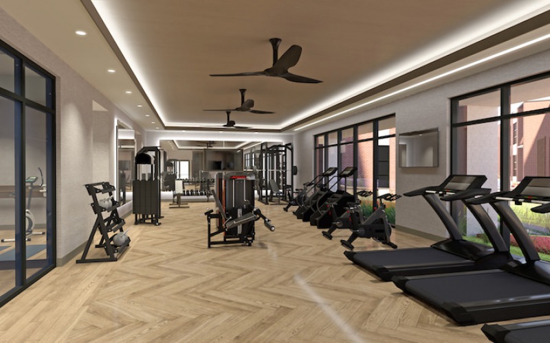 Large fitness center with wood floors and large windows